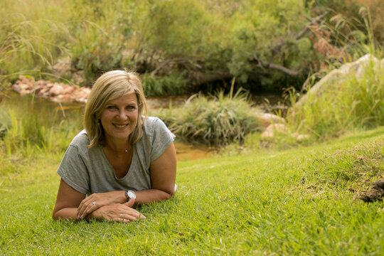 Woman Lying Next To Stream (Baby Boomer)