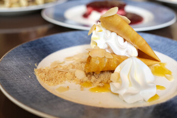 Crepe with lemon sauce. Homemade crepes with lemon curd and slices almond on wooden table. Lemon pancakes with sauce and cream. Crepes with cream and lemon curd.