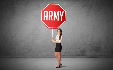 Obraz premium Young business person holding road sign