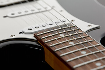 Electric guitar, closeup view on wooden fretboard