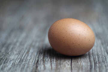 Single brown egg on the wooden table, selective focus