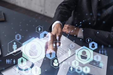 Recruitment concept to hiring of a new talented specialists for international company. Handshake to sign in of employment agreement. Social media hologram icons. Women in business concept.