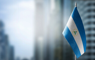 A small flag of Nicaragua on the background of a blurred background