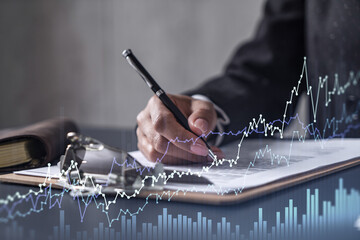 African American businesswoman in formal wear is signing the contract to invest money in stock market. Internet trading and wealth management. Forex and financial hologram chart.