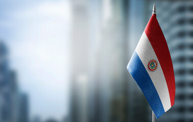 A small flag of Paraguay on the background of a blurred background