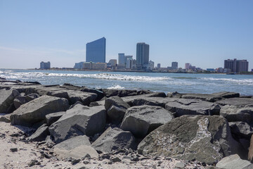 View on large hotel casino buildings with a rocky jetty in the foreground © ALAN