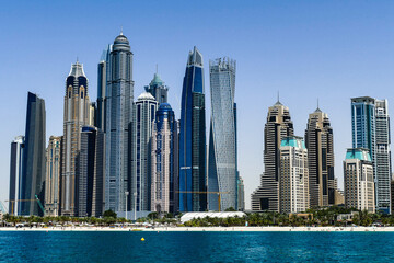 Fototapeta na wymiar Dubai, United Arab Emirates. Horizontal view of modern buildings and constructions in Dubai seen from the sea.