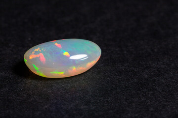 Colorful opal gem on black background