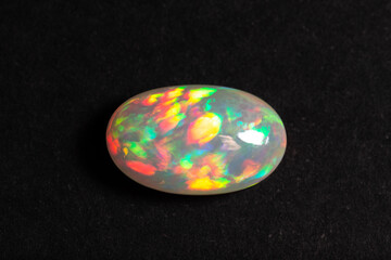 Colorful opal gem on black background