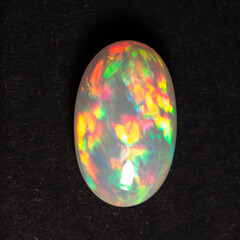 Colorful opal gem close-up on a black background