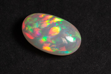 Colorful opal gem on black background