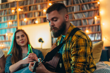 Man playing guitar for his girlfriend at home