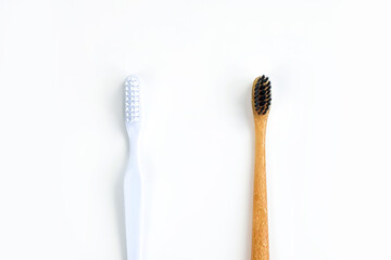 Bamboo toothbrush vs plastic toothbrush concept. Toothbrushes isolated on white background. Save the world. Copy space