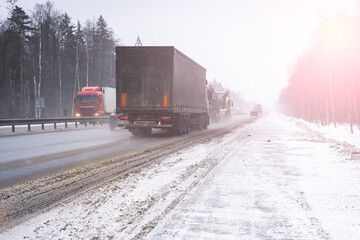 Trucks on the highway in dirty weather, Dangerous driving conditions in winter in cloudy weather.