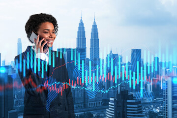 Attractive black businesswoman trader processing conference call to forecast the capital market behavior. Concept of trading strategy. Forex chart. Kuala Lumpur. Double exposure.