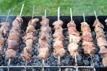 barbecue on the grill close-up, a lot of skewers with meat on the grill