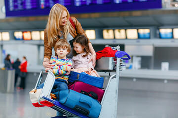 Two little kids, boy and girl, siblings and mother at the airport. Children, family traveling,...
