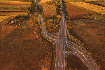 Vehicles on the road intersection through countryside landscape