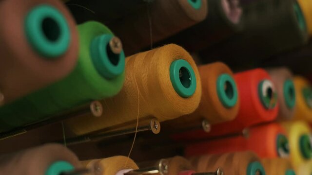 Spools of colored thread on a vertical stand.