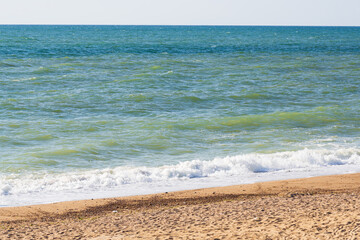 Wind and big waves on a sandy beach