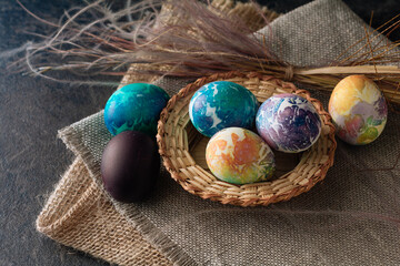 multi-colored Easter eggs of blue tones on a brown cloth background.