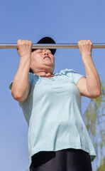 Naklejka premium Asian woman working out lifting a metal bar
