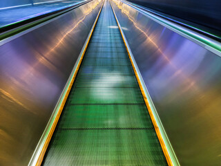 Fototapeta premium Long empty illuminated escalator people mover