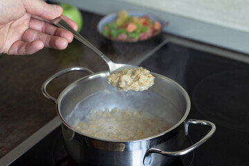 A man is engaged in household chores. She cooks breakfast, washes dishes, and waters the flowers. Close-up. Space for text