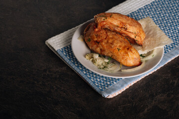 Delicious grilled chicken breasts on a plate on the dark background