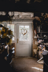 A florist's workshop with a wreath hanging from door