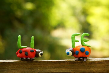 Two figures of ladybirds made of plasticine. Next to it is the inscription life.