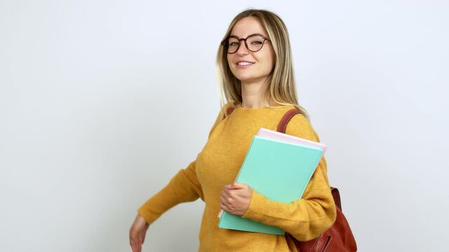Young woman with backpack pointing back and presenting a product over isolated background