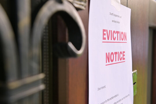 the notice of eviction of tenants hangs on the door of the house, front view