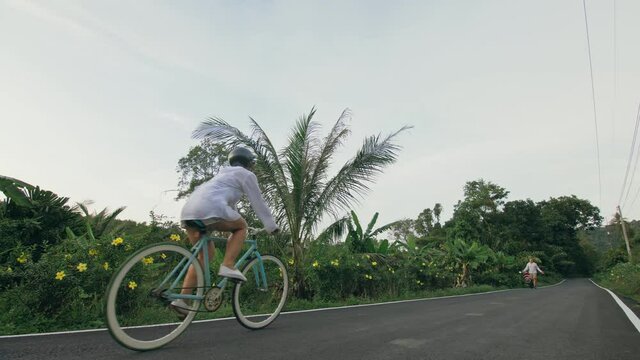 Biking road trip. The woman on blue bike in white clothes on forest road. The girl ride on bicycle. Cycling Cycle Fix. Asia Thailand ride tourism.