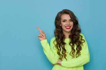 Fototapeta premium Young Smiling Woman Is Pointing Up