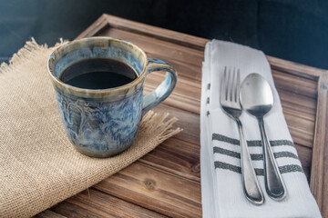 Coffee cup with silverware and burlap