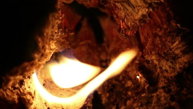 Hot coals in a bonfire at night.