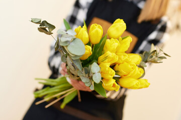 florist woman holding bouquet of fresh yellow tulips