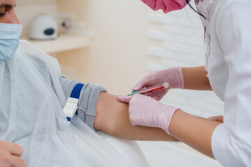 Close-up take blood from a person's vein for analysis and testing for viruses. Formation of the immune system and antibodies.