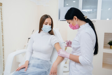 Vaccination of a girl against flu and coronavirus infection during a worldwide pandemic. The formation of the immune system and antibodies.