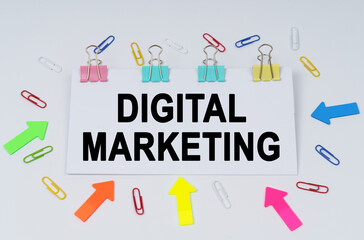 On the table there are paper clips and directional arrows, a sign that says - DIGITAL MARKETING