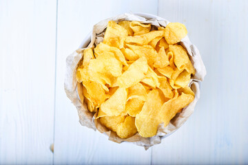 Potato chips and bowl. Chip on white background Fries are snacks. Top view. Copy space Horizontal orientation