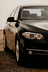 Fototapeta na wymiar Headlight of modern prestigious black car close up.