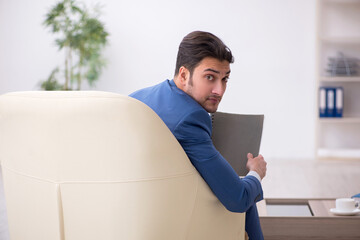 Young male employee waiting for business meeting