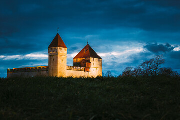 Fototapeta premium Kuressaare, Saaremaa Island, Estonia. Episcopal Castle In Evening Blue Hour Night. Traditional Medieval Architecture, Famous Attraction Landmark. Old Tower.