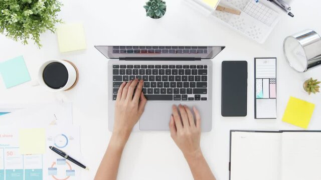 Top view of freelance Asia lady casual wear using laptop in living room at house. Working from home, remotely work, distance education, social distancing, quarantine for corona virus prevention.
