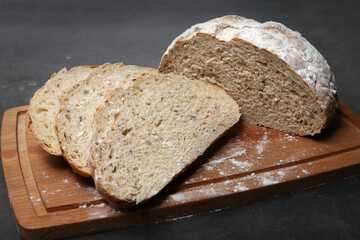 Freshly baked round bread sliced on a wooden chopping board. The concept of a bakery, a bakery