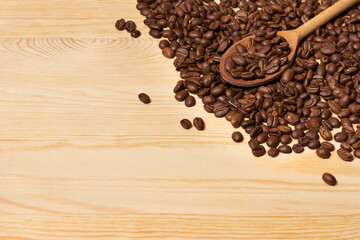 A wooden spoon lies on coffee beans
