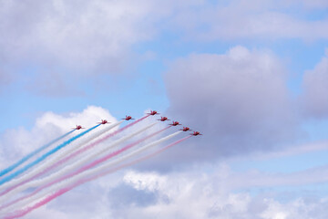 royal air force airshow team flying with red, white, and blue smoke 