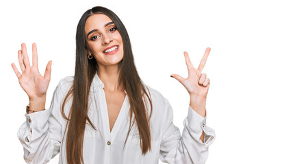 Young beautiful woman wearing casual white shirt showing and pointing up with fingers number eight while smiling confident and happy.